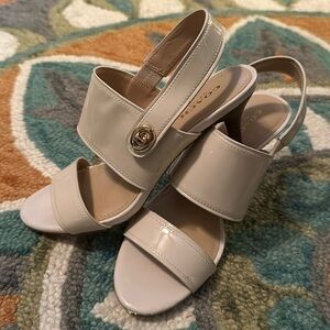 White kitten heeled patten leather sandals by Coach.